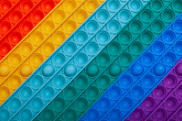 istock Surface of multi-colored rubber children's toy POP IT, close-up. Tap on bubble, finger game. Top view, copy space 1340266852