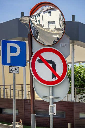 Mirror and traffic signs on a street corner In the Portuguese town Lagoa is today a suburb to Ponta Delgada which is the main city on the Azorean Island San Miguel in the center of the North Atlantic Ocean.