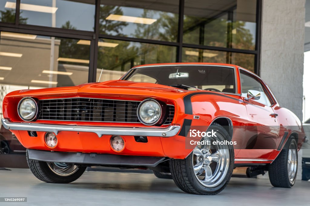 Classic vintage muscle car orange muscle car front left corner low shot Sports Car Stock Photo