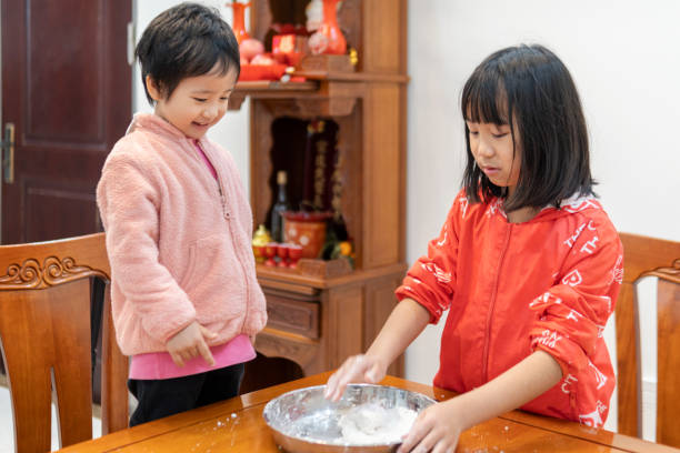 istock Asian sisters kneading dough to make dumpling wrappers at home 1340271360