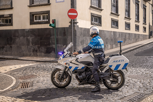 Policeman on duty with a motorbike in the Portuguese city Ponta Delgada which is the main city on the Azorean Island San Miguel in the center of the North Atlantic Ocean.