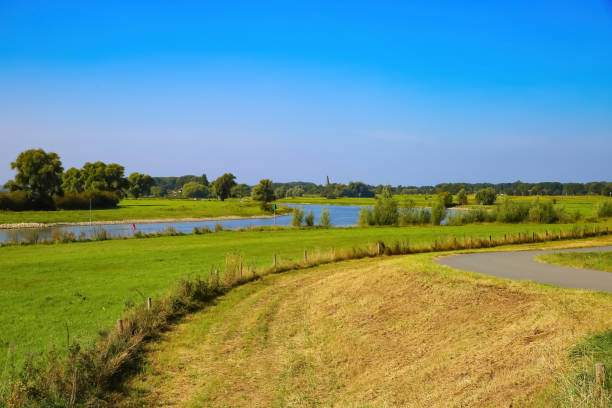 istock View from cycling track on typical dutch rural landscape with agricultural fields and river Ijssel against blue summer sky 1340275040