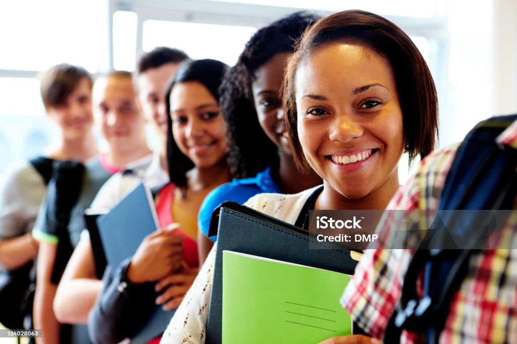 Multirazziale studenti in piedi in una riga sorridente - Foto stock royalty-free di Adolescente