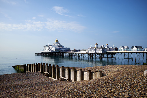 Eastbourne Seafront and Pier, East Sussex, England. A low angle view across the pebbles towards the Victorian pier.