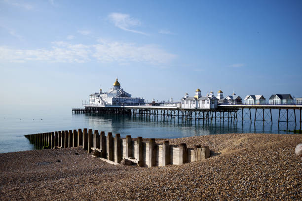 Eastbourne Seafront and Pier, East Sussex, England. A low angle view across the pebbles towards the Victorian pier. Eastbourne Seafront and Pier, East Sussex, England. A low angle view across the pebbles towards the Victorian pier. eastbourne pier photos stock pictures, royalty-free photos & images