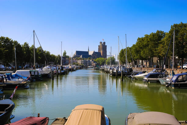 View on dutch water canal with yacht harbour, gothic church background against blue summer sky Dordrecht, Netherlands - View on dutch water canal with yacht harbour, gothic church background against blue summer sky dordrecht stock pictures, royalty-free photos & images