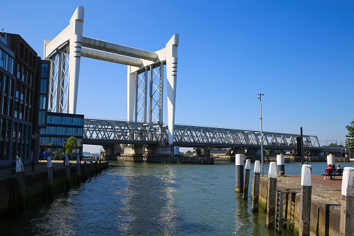 Dordrecht, Netherlands - July 9. 2021: View over river on modern dutch railway steel bridge against blue summer sky