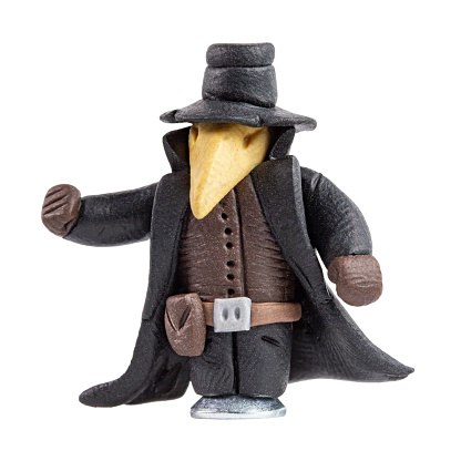 The figure of a mystical character with a grotesque nose in a high hat and a black cloak, made of plasticine.