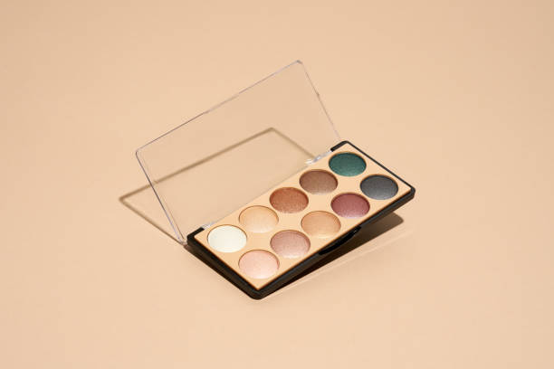 Make-up palette floating over a beige background Make-up palette floating over a beige background. Professional multicolor eye shadow make-up palette. Cosmetic products eyeshadow stock pictures, royalty-free photos & images