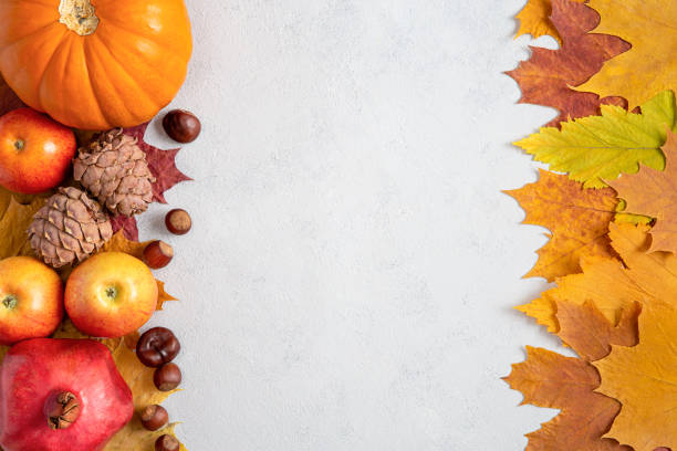istock Autumn frame with yellow maple leaves, nuts, apples and pumpkin. Fall harvest on concrete gray background flat lay with copy space. 1340286410