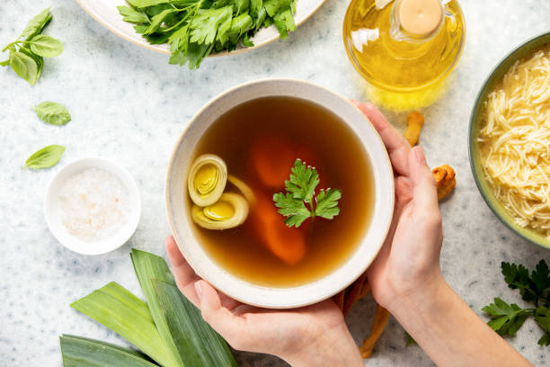 Bone broth in a bowl, top down view stock photo