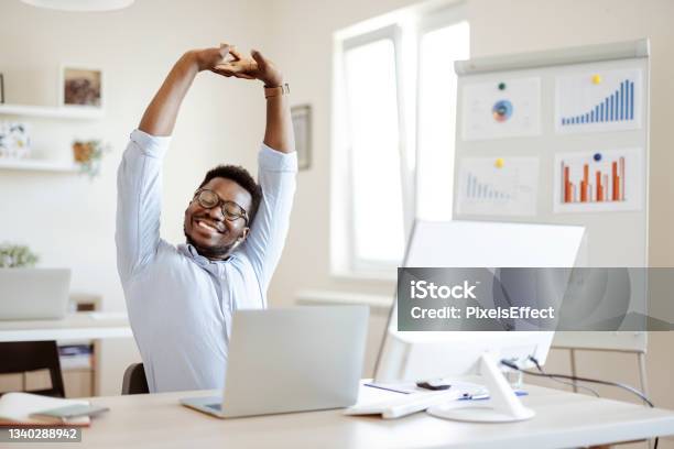 Businessman Stretching His Arms Stock Photo - Download Image Now - Stretching, Desk, Working