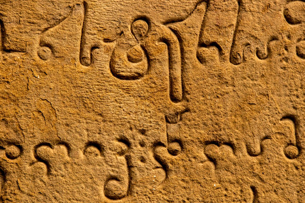 close-up ancient carving of mkhedruli alphabet developed between the 11th and 13th centuries - official language of georgia - on old grainy sandstone wall. - mtskheta imagens e fotografias de stock