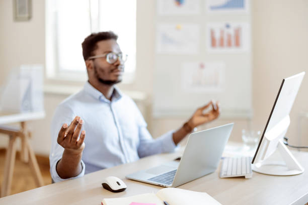 Some meditation before work Relaxation At Work. Afro businessman meditating at work, dealing with stress and anxiety. Free space meditation room office stock pictures, royalty-free photos & images