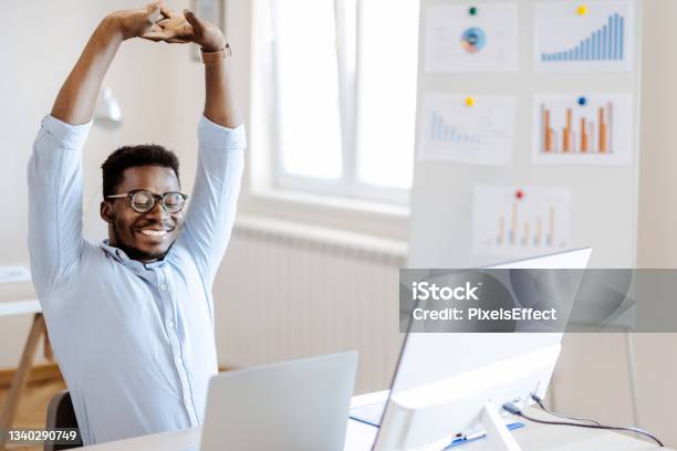 Man Stretches At Office Desk Stock Photo - Download Image Now - Exercising, Office, African-American Ethnicity