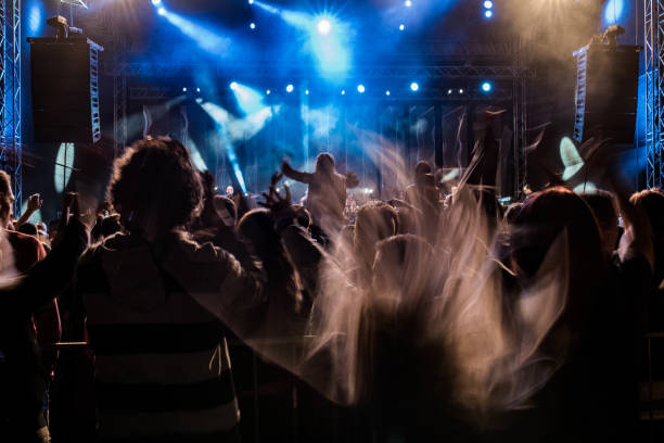 istock People enjoying rock concert, motion blurred headbanging fans 1340290844