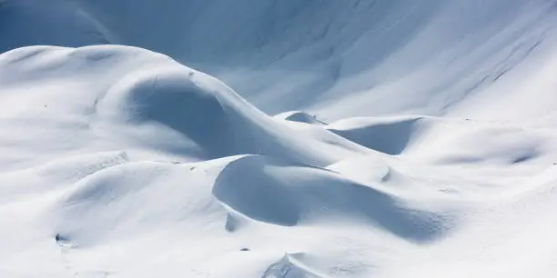 White snowdrifts making various round shapes. Winter mountain landscape background. Vogel, Julian Alps, Slovenia.