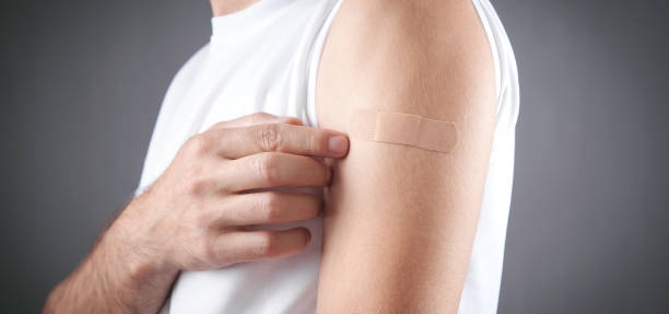 istock Caucasian man shows his shoulder with a bandage after vaccination. 1340294277