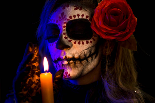 istock Sugar skull creative make up for Halloween ,young woman holding candle 1340294619