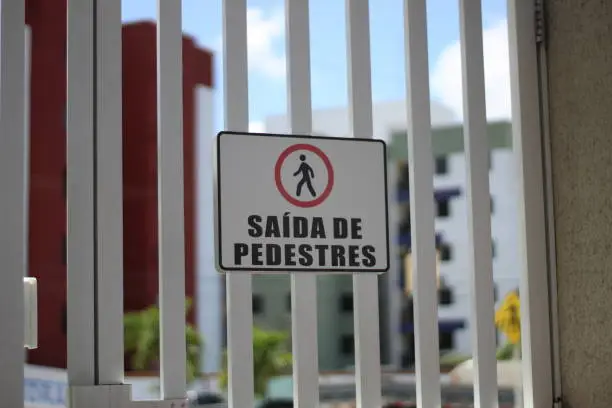 Pedestrian exit from a residential condominium in Portuguese.