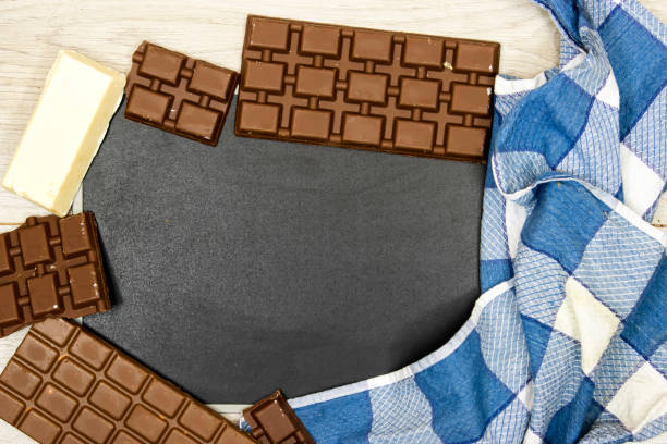 leite e barras de chocolate preto, branco com placa preta vazia sobre mesa de madeira - chocolate candy unhealthy eating eating food and drink - fotografias e filmes do acervo