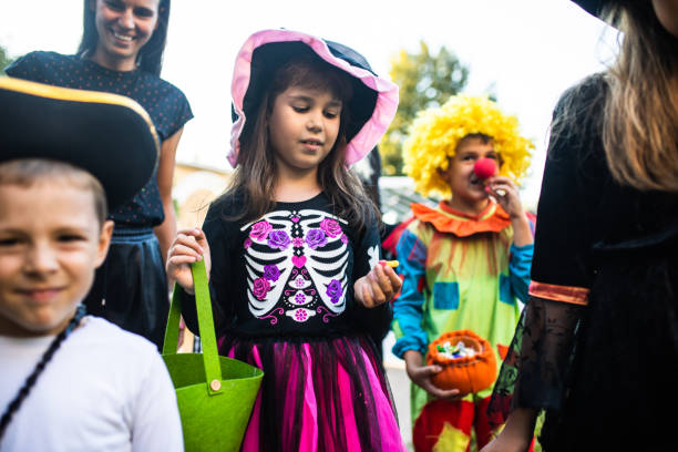 istock Kids trick-or-treating with their parents 1340298075