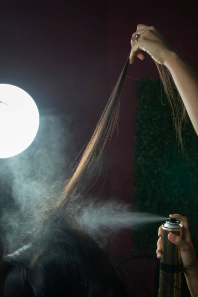создание прически с помощью лака для волос в салоне крупным планом фото - hairspray стоковые фото и изображения