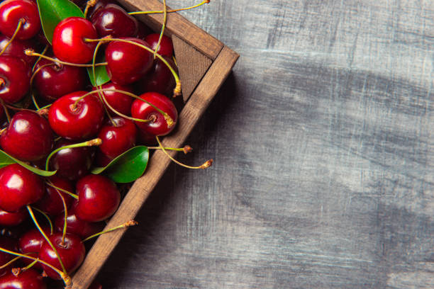 Cherries Fresh cherries in a wood container, gray background. healthy eating red above studio shot stock pictures, royalty-free photos & images