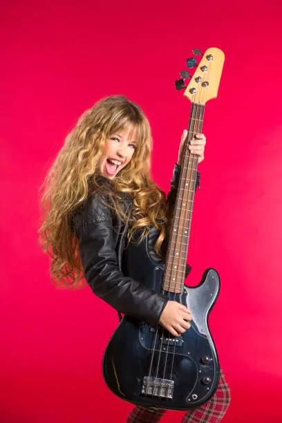 Blond Rock and roll girl playing bass guitar on red background