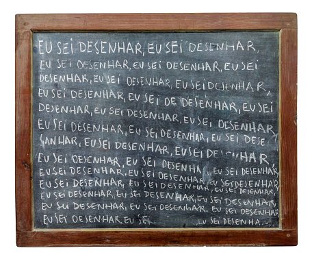 blackboard with words written in white chalk. The blackboard is filled with the same single sentence in portuguese: \