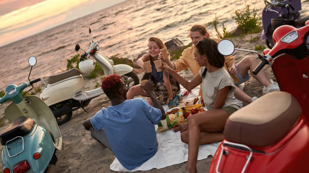 istock Joyful young people spending good time together while sitting on the beach and drinking soda 1340304122