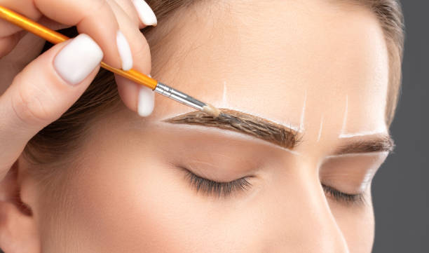 make-up artist makes markings with white pencil for eyebrow and paints eyebrows. professional makeup and facial care. - portrait tattoo photography color image imagens e fotografias de stock