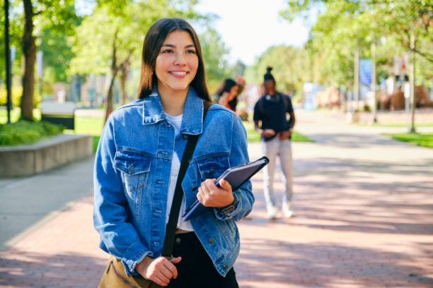 College Student on Campus A young woman college student, standing on campus. back to school teens stock pictures, royalty-free photos & images