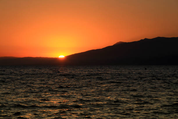 Seascape with mountains and orange sky at sunset in Cabo de Gata, Almeria, Spain