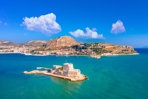 The old town of Nafplion in Greece with tiled roofs, small port, bourtzi castle, Palamidi fortress