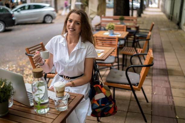 istock Businesswoman using laptop while enjoying work at cafe table with cup of coffee 1340312944
