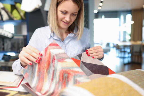istock Woman designer decorator chooses fabrics for curtains embroidering fabrics carpets in textile show room closeup 1340313078