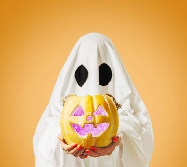 istock Halloween cute ghost holding glowing jack-o-lantern pumpkin. 1340315235