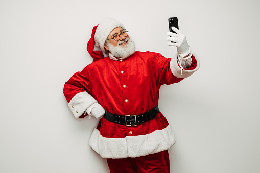 Happy, real, funny Santa Claus taking selfie