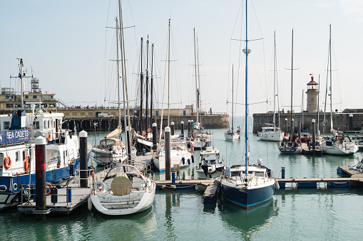 Ramsgate, UK - Sep 9 2021 A collection of boats and yachts, including a tall ship in Ramsgate Royal harbour. The entrance to the habour can be seen and the lighthouse