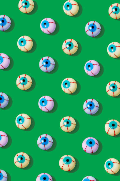 Creative layout with colorful bloody eyeball on a vivid green background. Minimal Halloween concept.