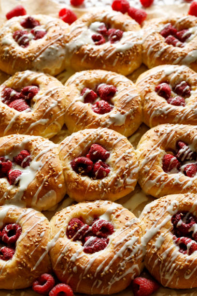 Homemade sweet yeast buns with raspberries and white chocolate, close up view. Delicious dessert