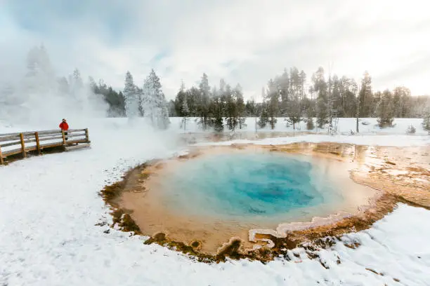 Woman visiting Yellowstone hot spring in winter