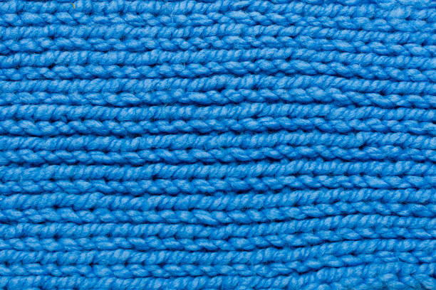 istock Knitted pattern of blue threads. Horizontal photo, drawing close-up. The pattern is made with knitting needles 1340332224