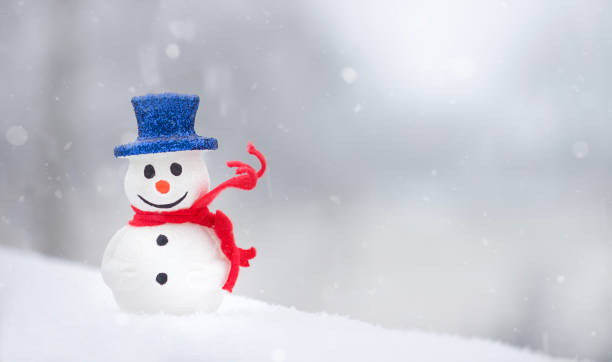 istock Snowman with red scarf on white snow background. 1340334231