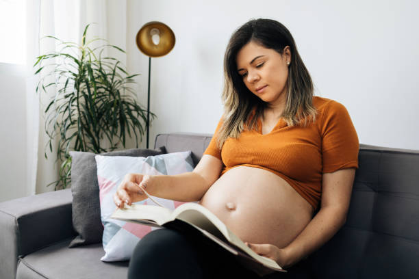 istock Pregnant woman relaxing at home reading a book. 1340335952