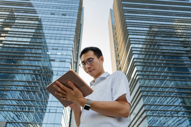 istock An Asian male businessman using a tablet under the office building 1340339932