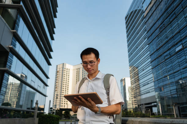 istock An Asian male businessman using a tablet under the office building 1340339991