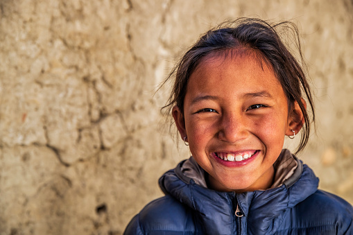 Portrait of Tibetan young girl from Lo Manthang, Upper Mustang. Mustang region is the former Kingdom of Lo and now part of Nepal,  in the north-central part of that country, bordering the People's Republic of China on the Tibetan plateau between the Nepalese provinces of Dolpo and Manang.