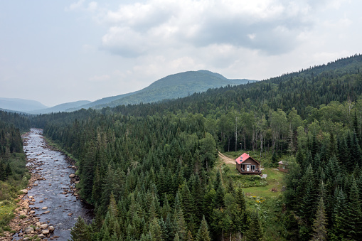 Aerial View of Boreal Nature Forest, River and Log Cabin in Summer, Quebec, Canada